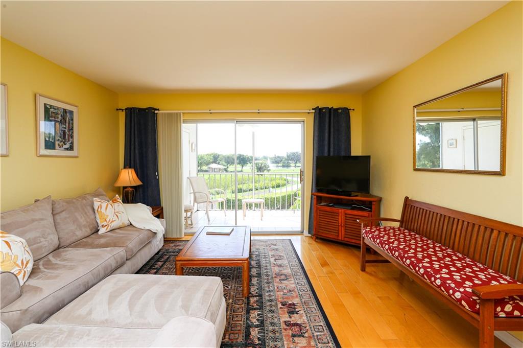 1075 Foxfire Lane, Unit 207 Naples, FL 34104 - Photo 7 of 26 a living room with furniture and a flat screen tv