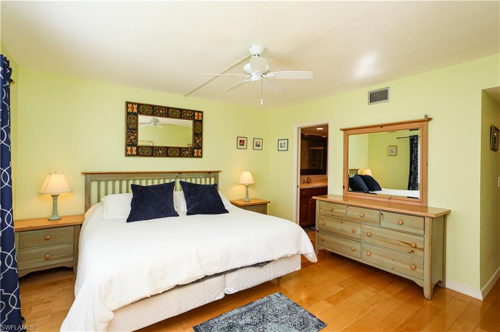 1075 Foxfire Lane, Unit 207 Naples, FL 34104 - Photo 10 of 26 a bedroom with a bed and a painting on the wall