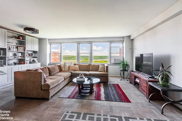 a living room with furniture hard wood floor and a flat screen tv