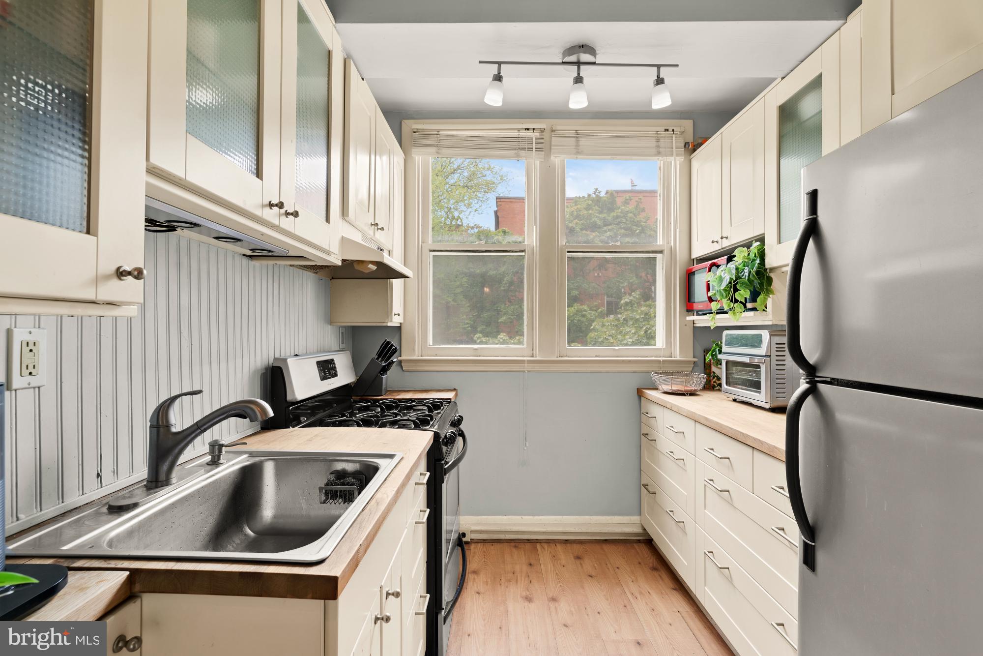159 West Lanvale Street, Unit 5 Baltimore, MD 21201 - Photo 12 of 34 a kitchen with white cabinets and a sink