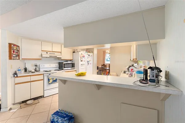 a kitchen with a sink a stove and white cabinets
