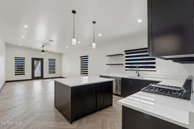 a kitchen with kitchen island a sink stainless steel appliances and cabinets