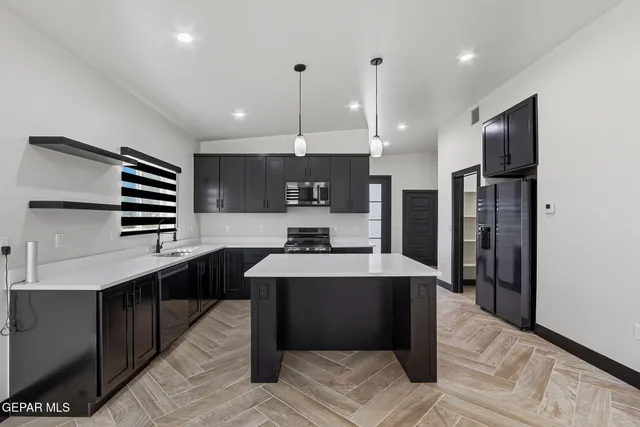 an empty room with wooden floor and a ceiling fan
