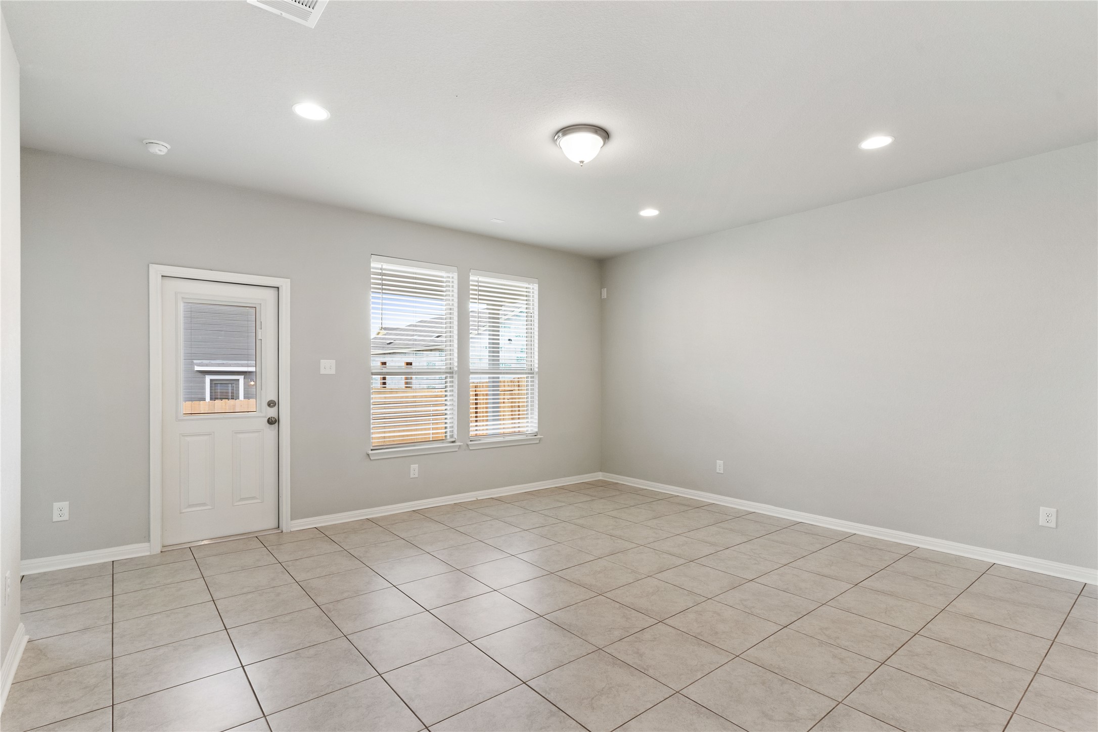 313 Mclintock Road Jarrell, TX 76537 - Photo 11 of 17 A well-lit area features two windows and durable tile flooring, offering versatile living space.