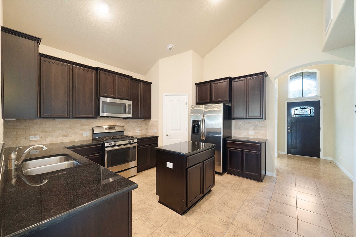 13720 Loleta Way Austin, TX 78717 - Photo 12 of 29 a kitchen with granite countertop a refrigerator and a stove top oven