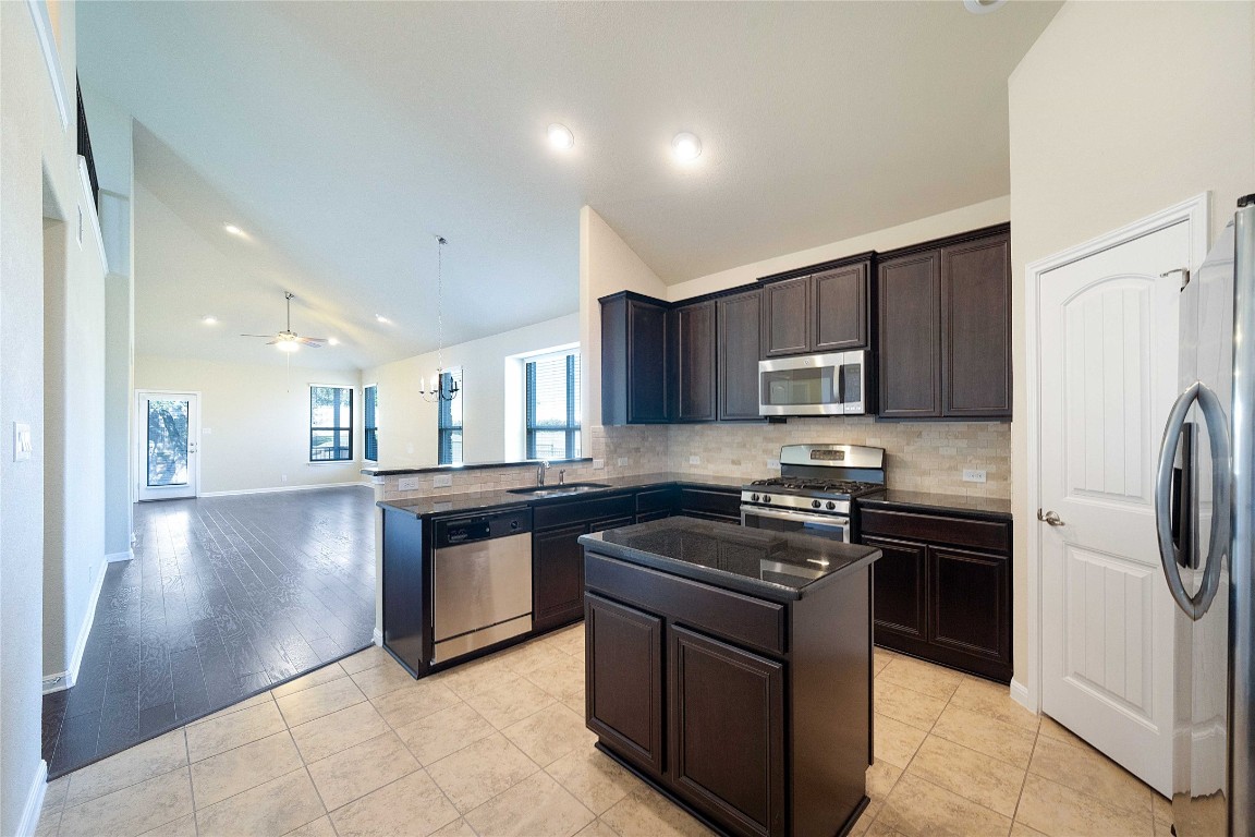 13720 Loleta Way Austin, TX 78717 - Photo 10 of 29 a kitchen with stainless steel appliances granite countertop a stove a sink and a refrigerator