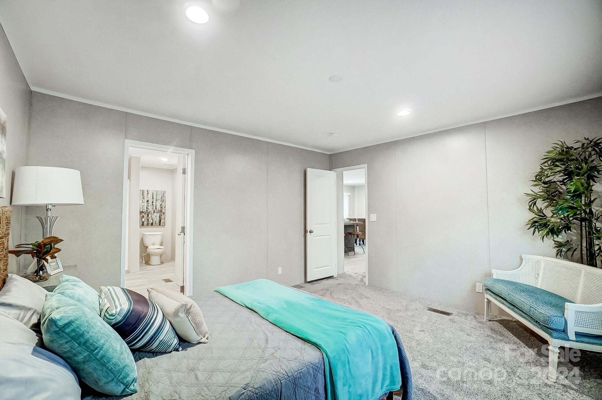 1860 Bascom Lane Midland, NC 28107 - Photo 17 of 27 a spacious bedroom with a bed and a potted plant