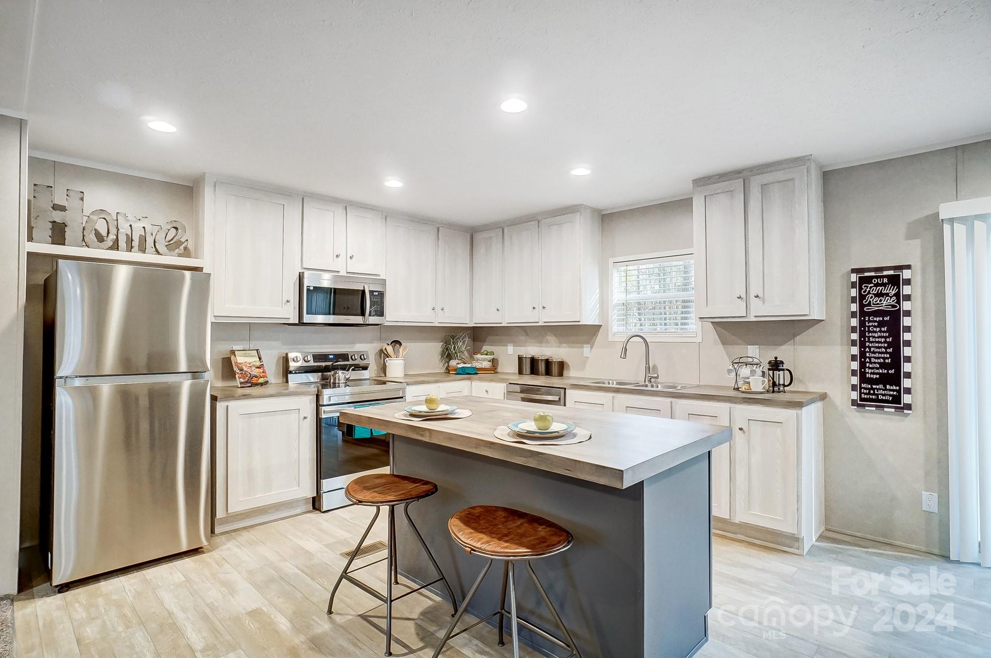 1860 Bascom Lane Midland, NC 28107 - Photo 2 of 27 a kitchen with a refrigerator a stove a sink and cabinets
