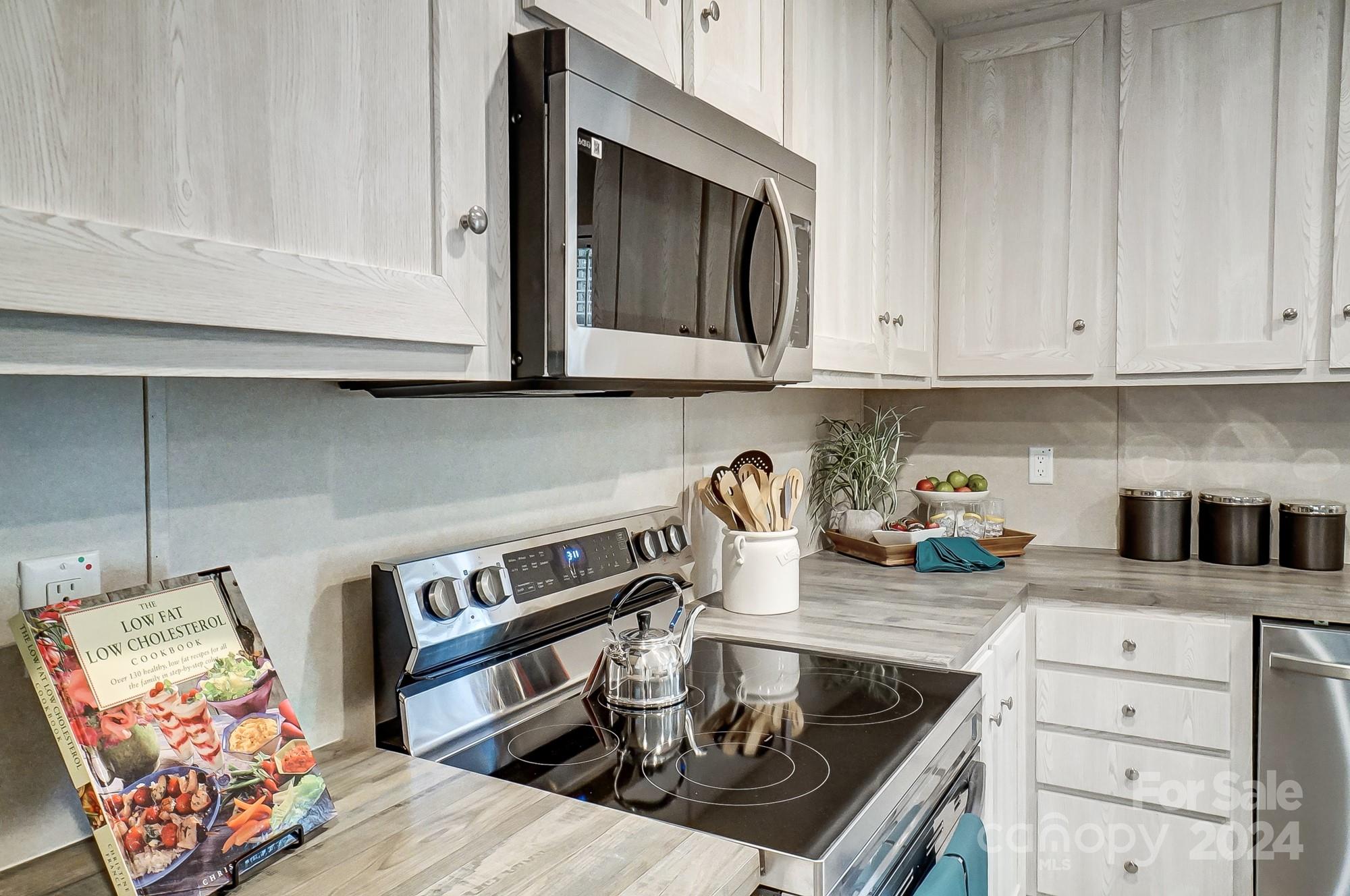 1860 Bascom Lane Midland, NC 28107 - Photo 5 of 27 a kitchen with stainless steel appliances granite countertop a stove and a microwave