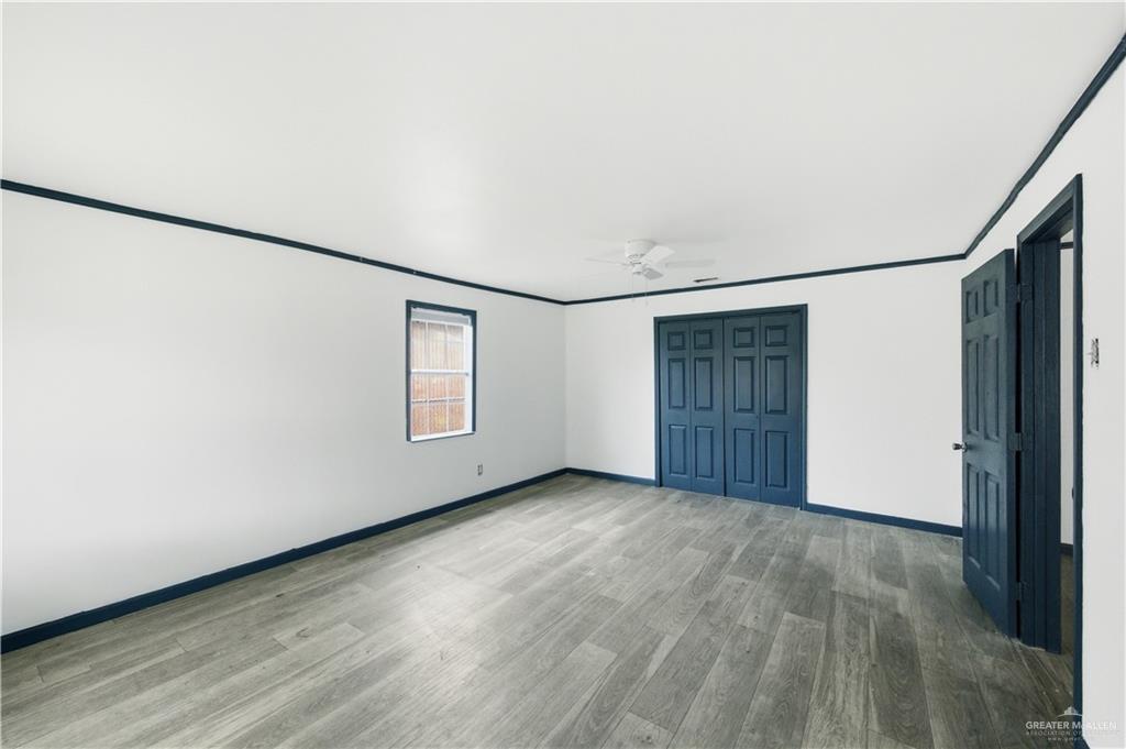 715 East Rusty Drive Pharr, TX 78577 - Photo 3 of 14 an empty room with wooden floor and windows
