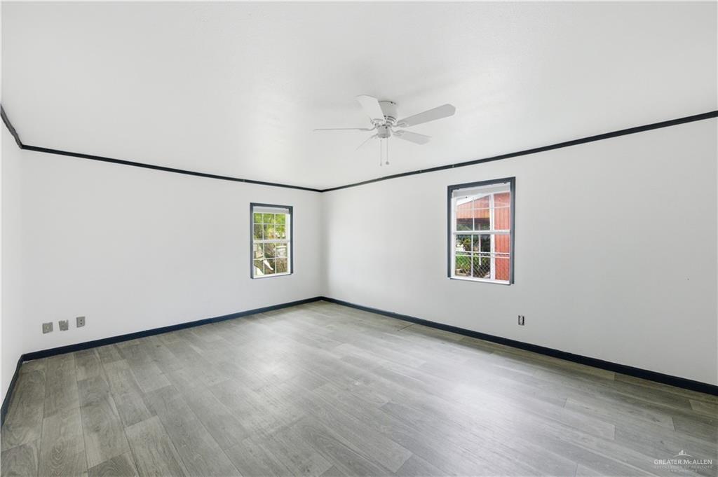 715 East Rusty Drive Pharr, TX 78577 - Photo 4 of 14 an empty room with wooden floor and windows