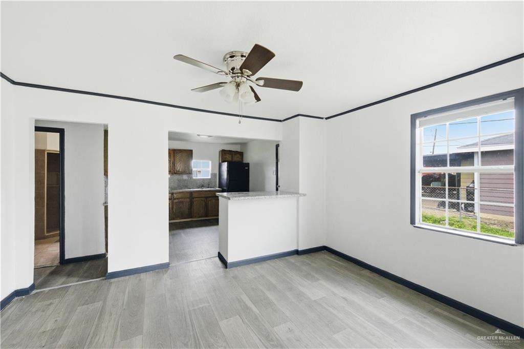 715 East Rusty Drive Pharr, TX 78577 - Photo 5 of 14 a view of a hallway with wooden floor and a kitchen