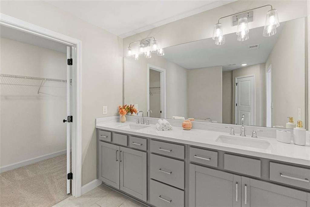 3739 Silvery Way Powder Springs, GA 30127 - Photo 15 of 28 a bathroom with a double vanity sink and a mirror