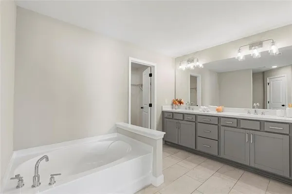 a bathroom with a tub sink and mirror
