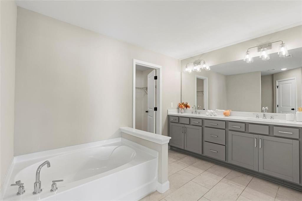 3739 Silvery Way Powder Springs, GA 30127 - Photo 16 of 28 a bathroom with a tub sink and mirror
