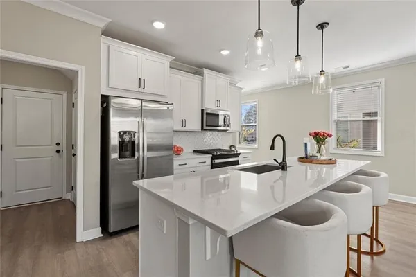 a kitchen with refrigerator and wooden floor
