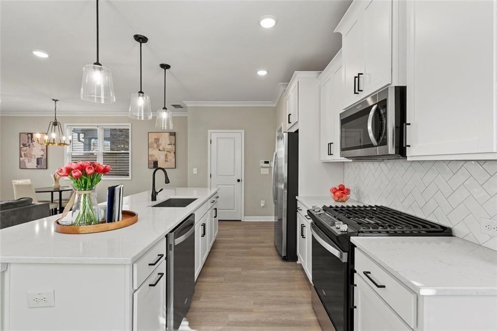3739 Silvery Way Powder Springs, GA 30127 - Photo 8 of 28 a kitchen with kitchen island granite countertop stainless steel appliances a sink a stove and cabinets