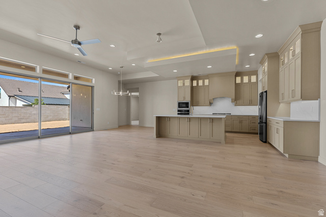 2955 East Rimrunner Drive St. George, UT 84790 - Photo 11 of 35 Open-concept living space featuring wood-finish flooring, a modern kitchen with light-toned cabinetry, a spacious island with a light-toned countertop, and recessed lighting