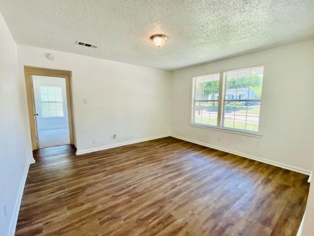 704 Nash Street Rockwall, TX 75087 - Photo 4 of 15 an empty room with wooden floor and windows