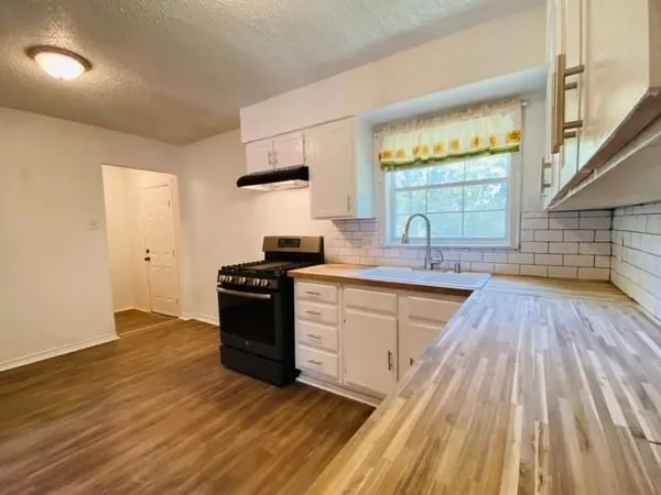 a kitchen with wooden floors and white appliances