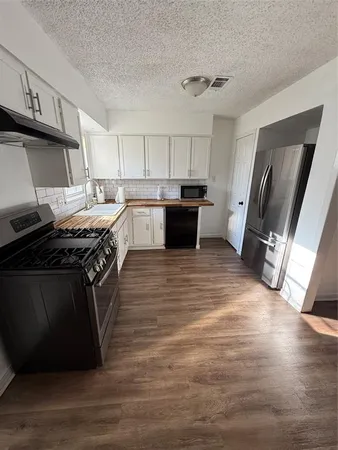 a kitchen with stainless steel appliances granite countertop a stove a sink and a refrigerator