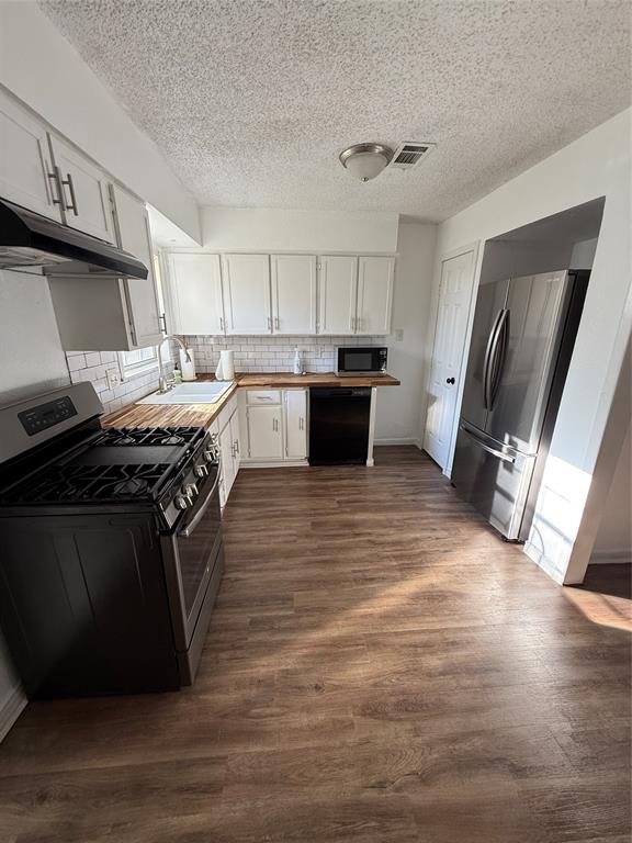 704 Nash Street Rockwall, TX 75087 - Photo 7 of 15 a kitchen with stainless steel appliances granite countertop a stove a sink and a refrigerator
