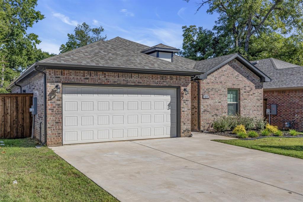 121 West Morton Street Denison, TX 75021 - Photo 2 of 28 a front view of a house with a yard and garage