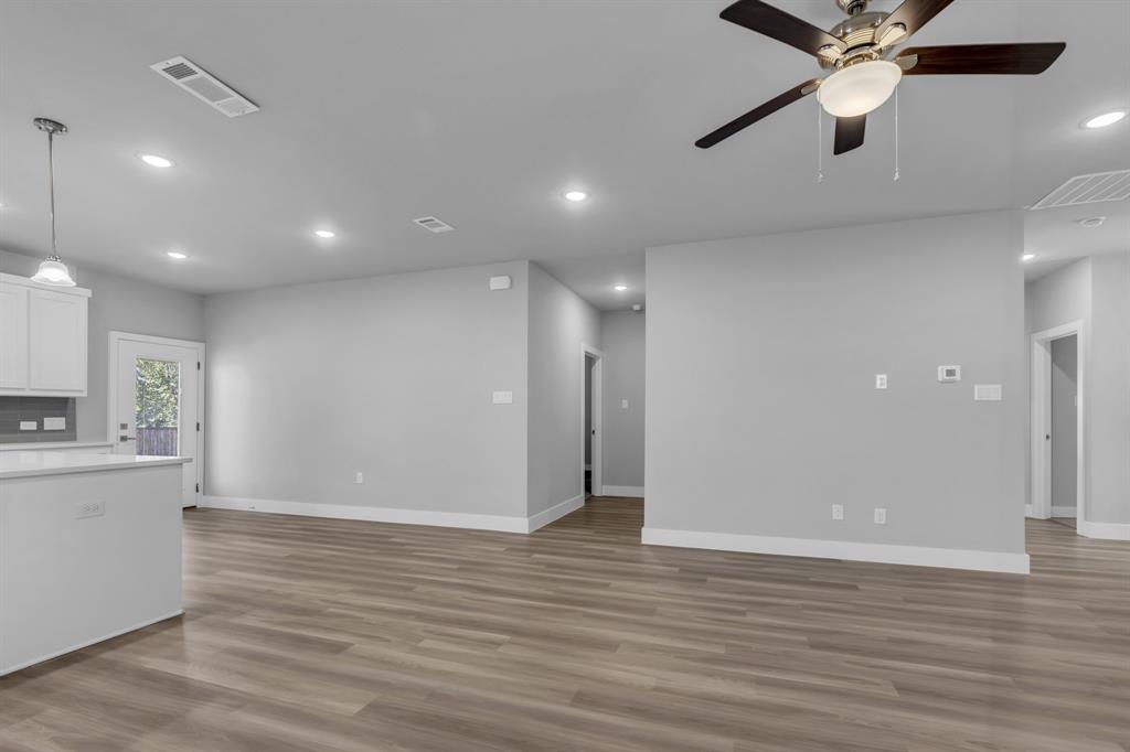 121 West Morton Street Denison, TX 75021 - Photo 9 of 28 a view of an empty room with a ceiling fan and wooden floor