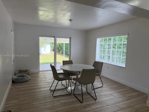 a view of a dining room with furniture a chandelier and wooden floor