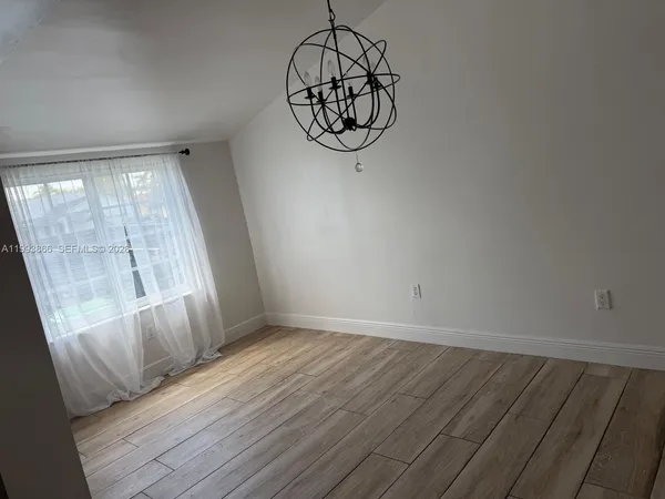 a view of a room with wooden floor and windows