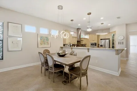 a dining area with a table chairs and a kitchen view