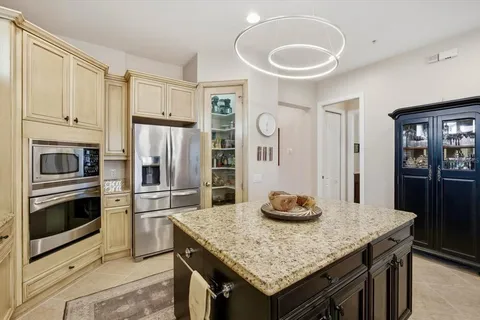 a kitchen with stainless steel appliances granite countertop a stove refrigerator and microwave