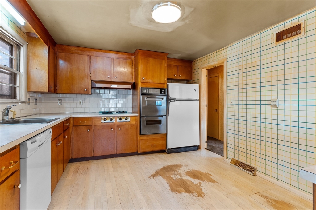 20 Joyce Road Framingham, MA 01701 - Photo 10 of 42 a kitchen with stainless steel appliances granite countertop a refrigerator a sink and wooden cabinets