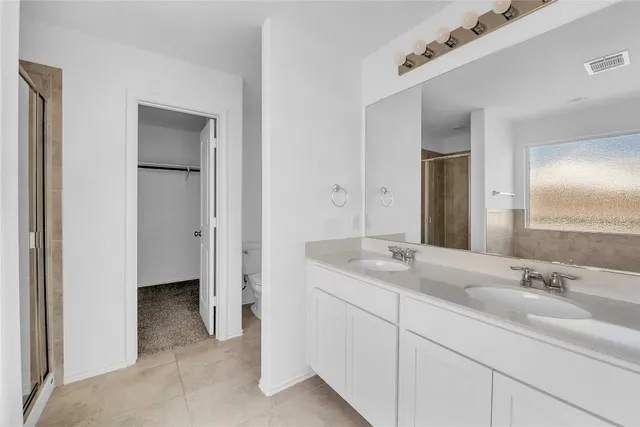 a bathroom with a double vanity sink and mirror