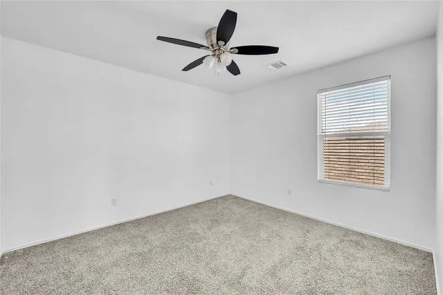 a view of room with a ceiling fan and window