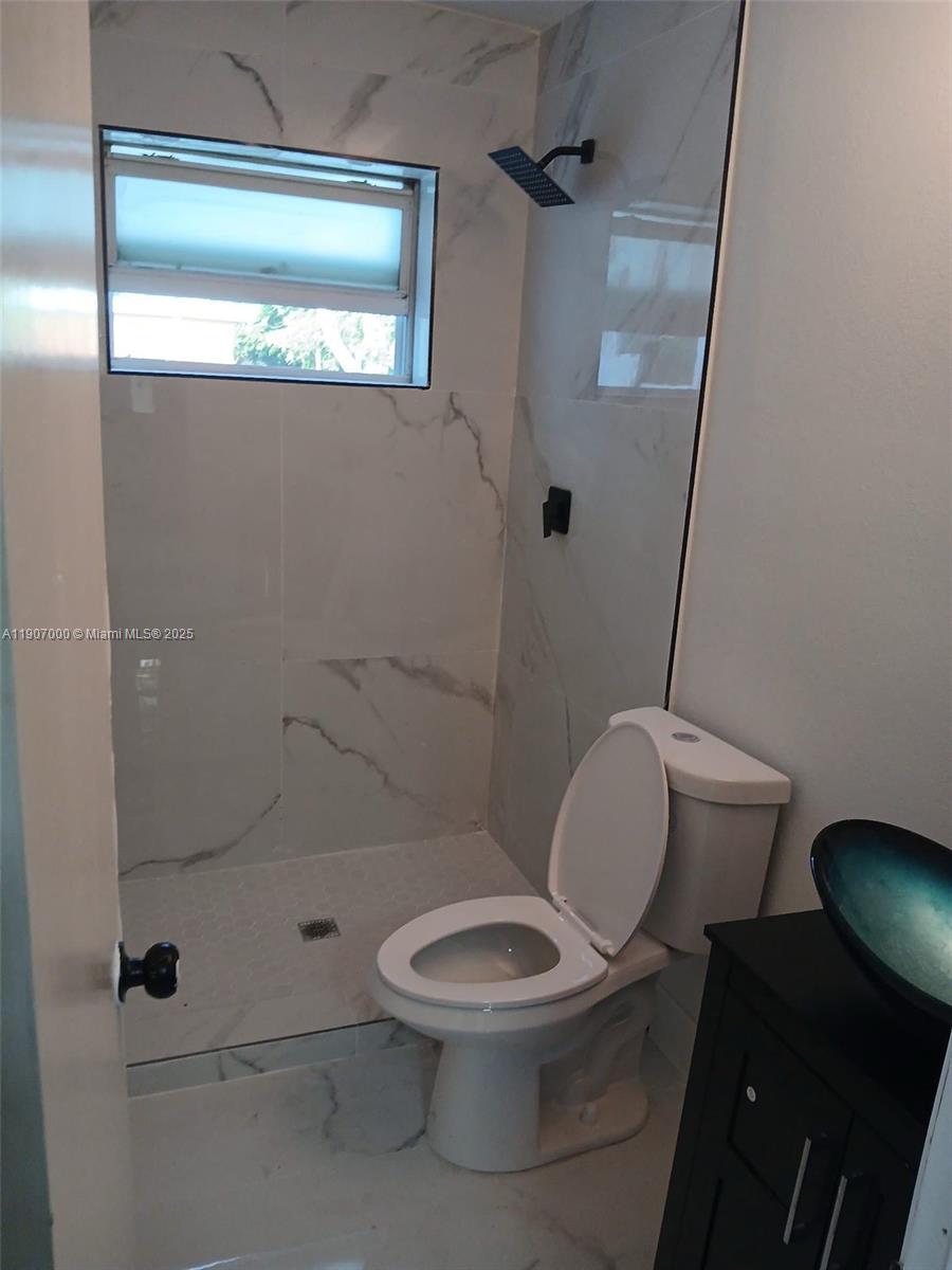 560 Northwest 188th Street, Unit 1 Miami Gardens, FL 33169 - Photo 2 of 4 a white toilet sitting next to a shower
