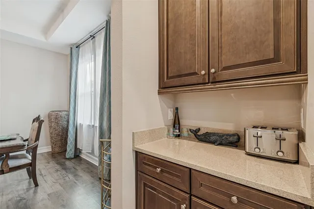 a dining table with stainless steel appliances kitchen island granite countertop a dining table chairs and a refrigerator