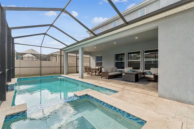 a kitchen with stainless steel appliances granite countertop a stove top oven a refrigerator a sink and chairs with wooden floor