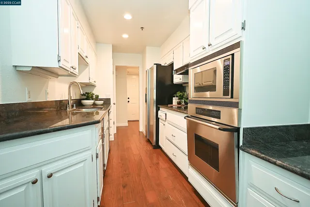 a kitchen with stainless steel appliances granite countertop a stove and a sink
