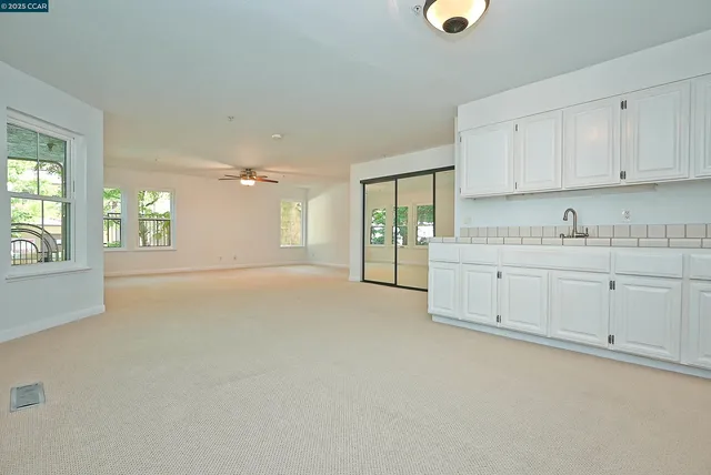 a view of a kitchen with a sink and dishwasher with white cabinets
