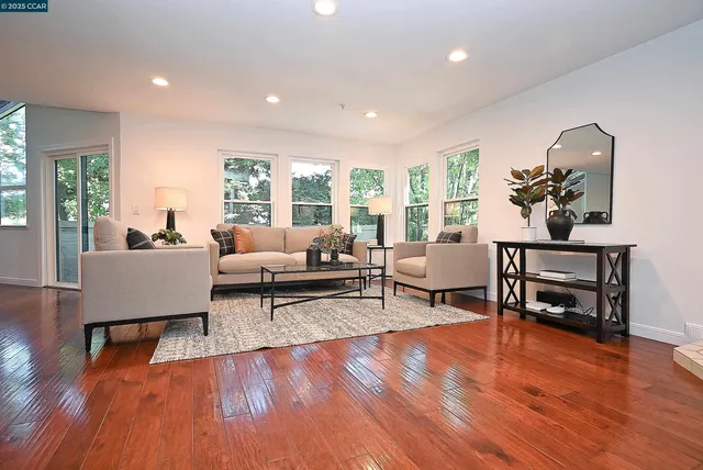 a living room with furniture and a wooden floor