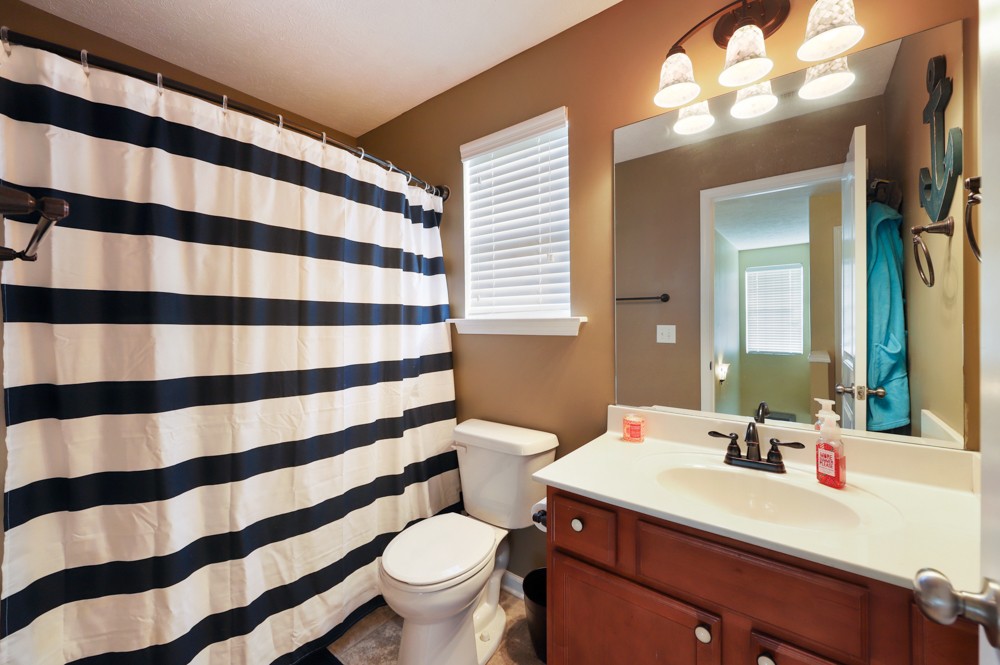 1080 Woodall Road Lebanon, TN 37090 - Photo 16 of 24 a bathroom with a sink a toilet a mirror and shower curtain