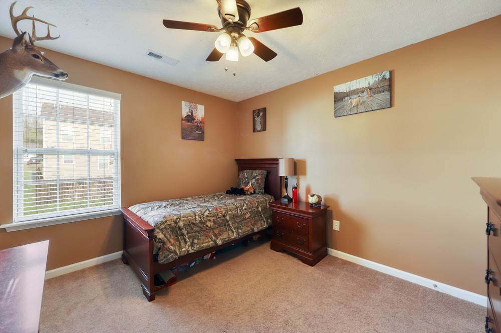 1080 Woodall Road Lebanon, TN 37090 - Photo 17 of 24 a bedroom with a bed and a chandelier fan