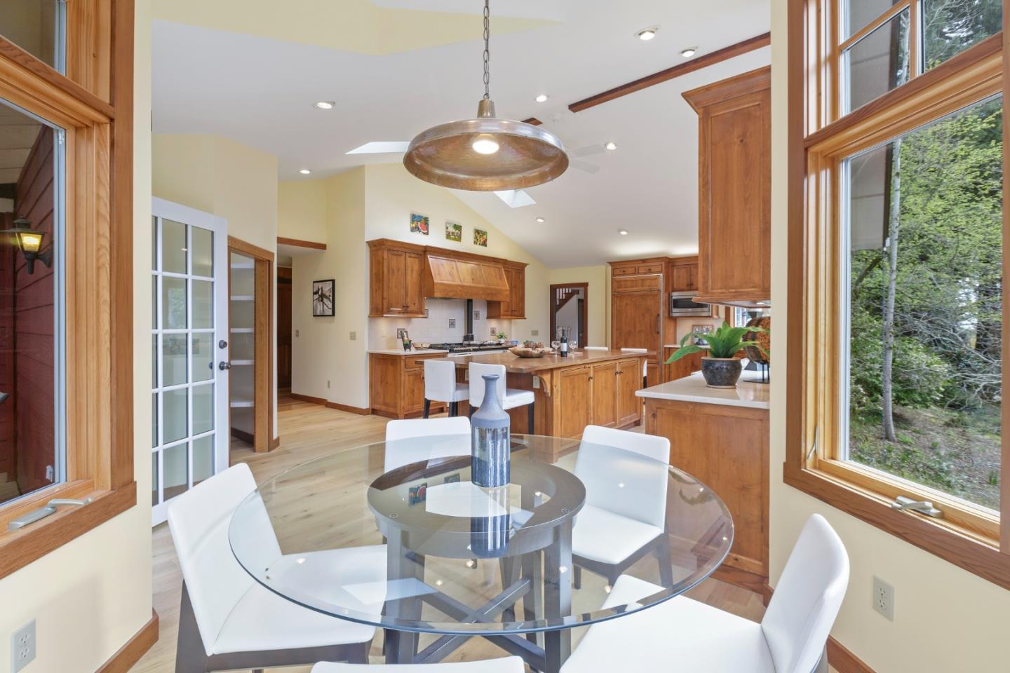 36 Skyline Drive Woodside, CA 94062 - Photo 25 of 67 a dining room with wooden floor a chandelier a glass table and chairs