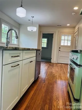 a kitchen with stainless steel appliances granite countertop a stove a sink and a refrigerator