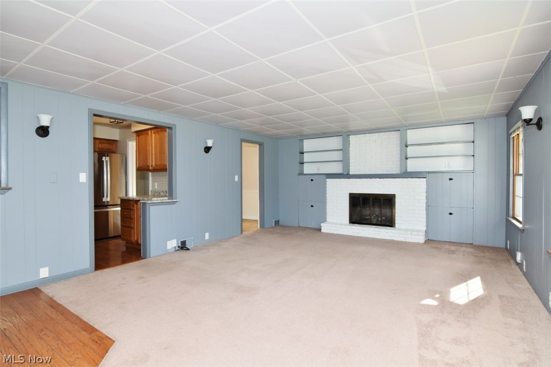 5284 Edenhurst Road Lyndhurst, OH 44124 - Photo 27 of 50 Living area featuring a white brick fireplace with hearth, built-in shelving, carpet flooring, and wall sconces