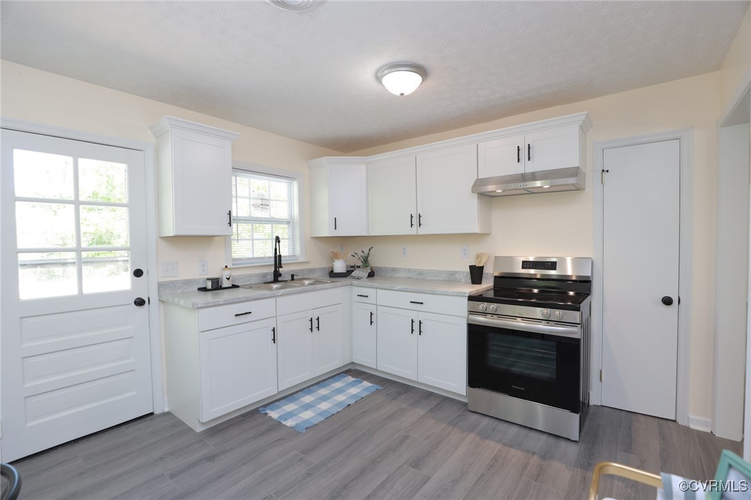 13077 Oral Oaks Road Victoria, VA 23974 - Photo 19 of 34 a kitchen with granite countertop white cabinets appliances and a window