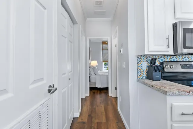 a view of a hallway with wooden floor and staircase