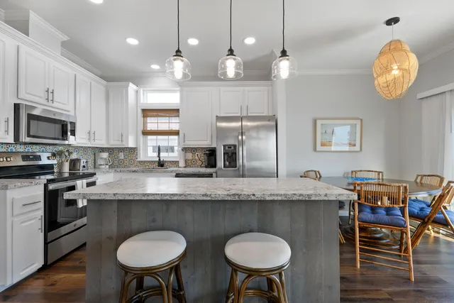 a kitchen with stainless steel appliances granite countertop a kitchen island a stove a table and chairs