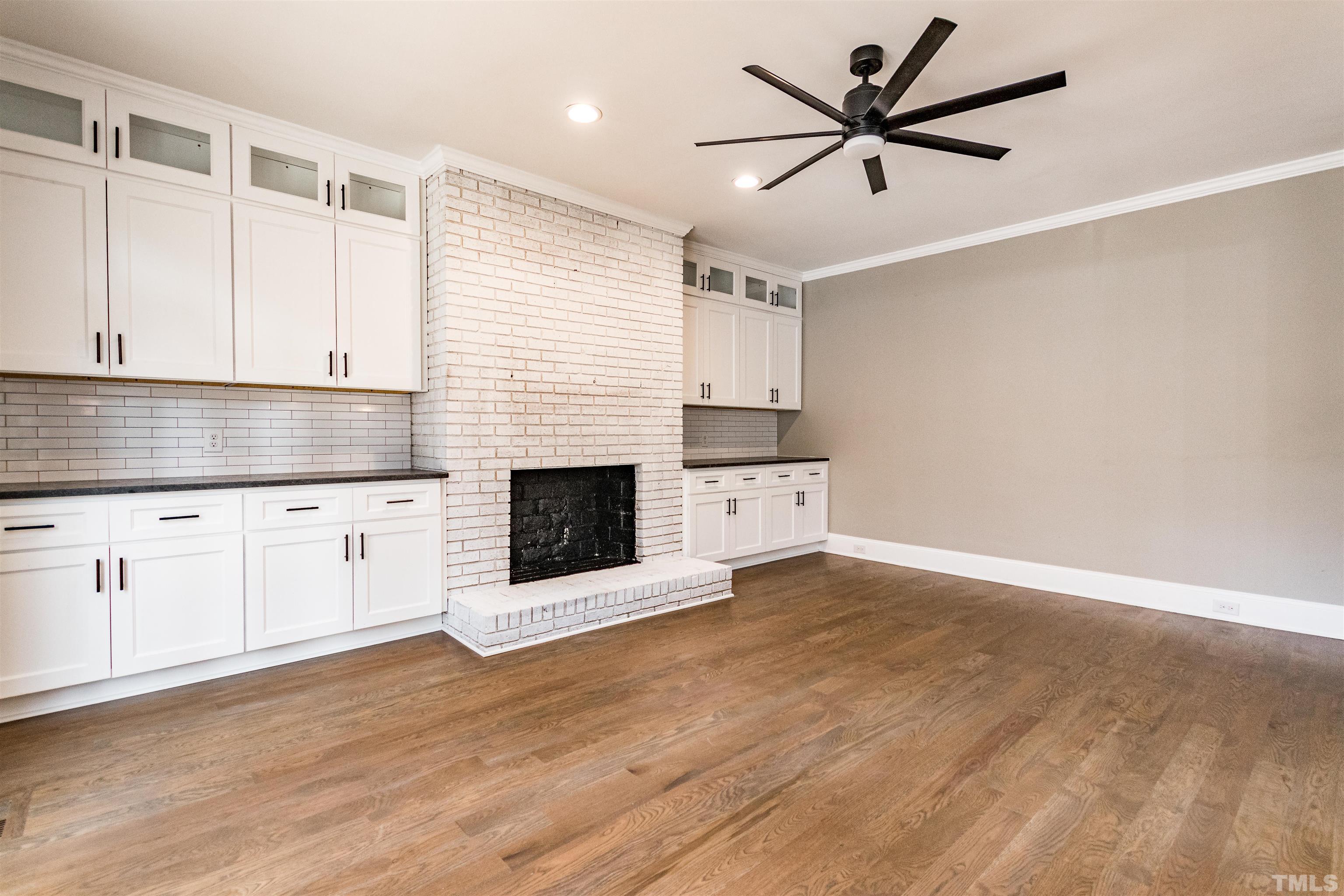 a kitchen with granite countertop a stove a sink and a fireplace